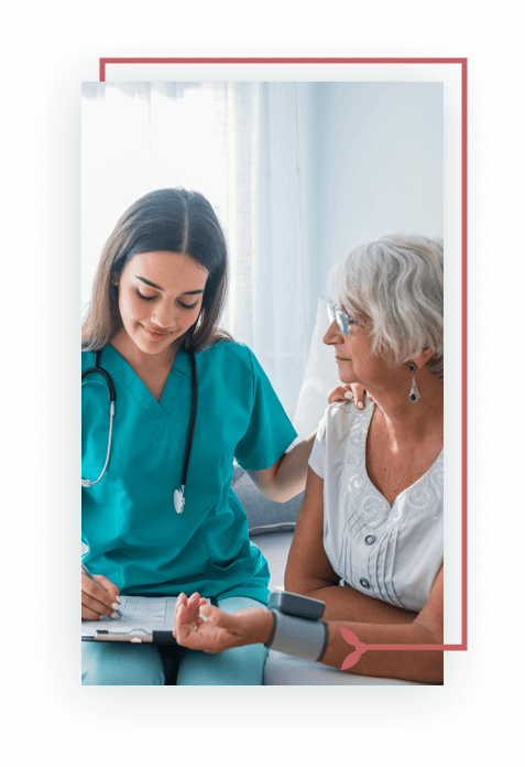 Senior woman sitting, young doctor, nurse in green scrubs, taking her blood pressure
